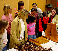 Professor Jane 
Farrell-Beck shows students pieces in the textiles collection.